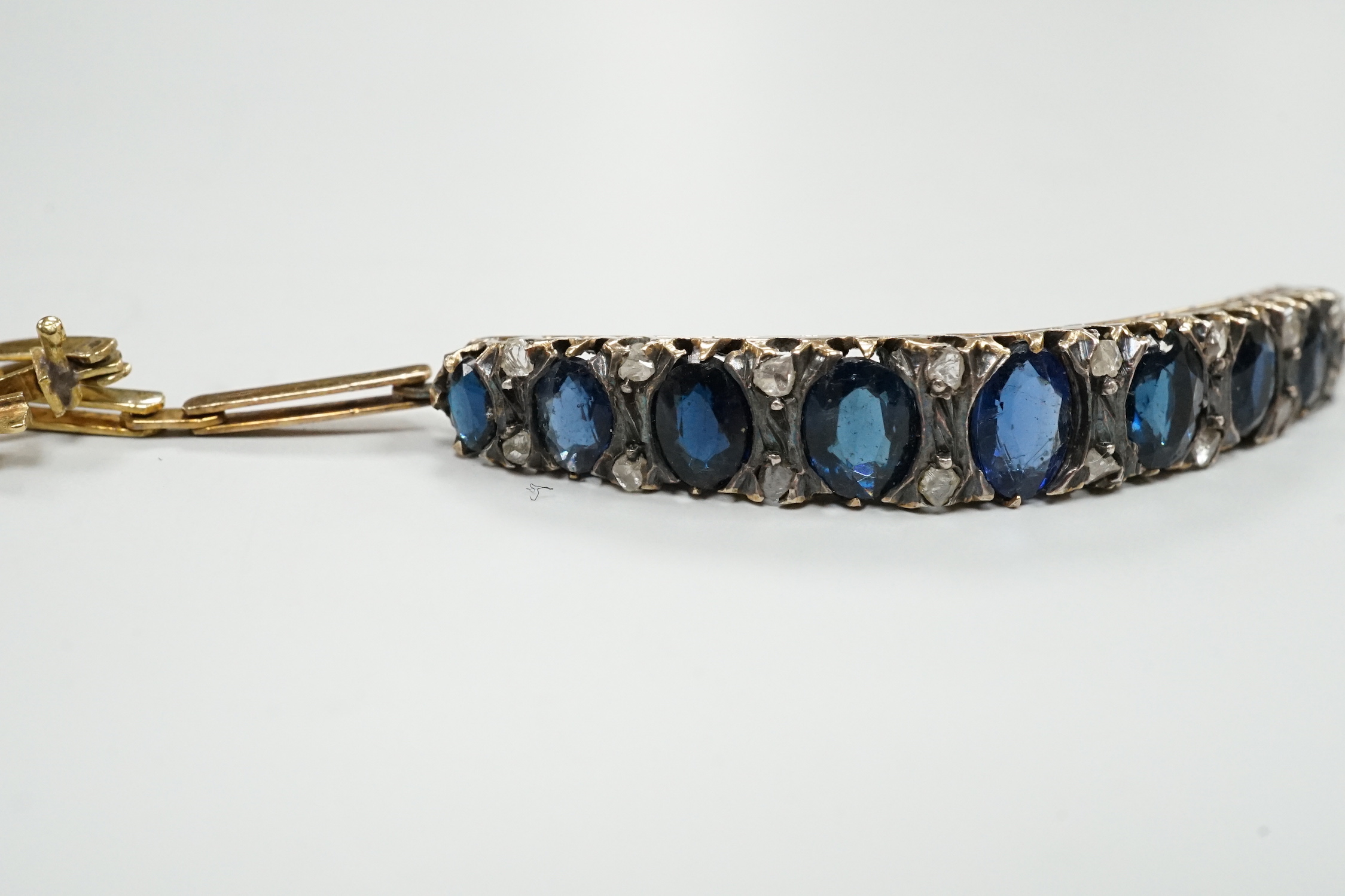 An Edwardian yellow metal, sapphire and rose cut diamond chip set bracelet, approx. 15cm, gross weight 8 grams.